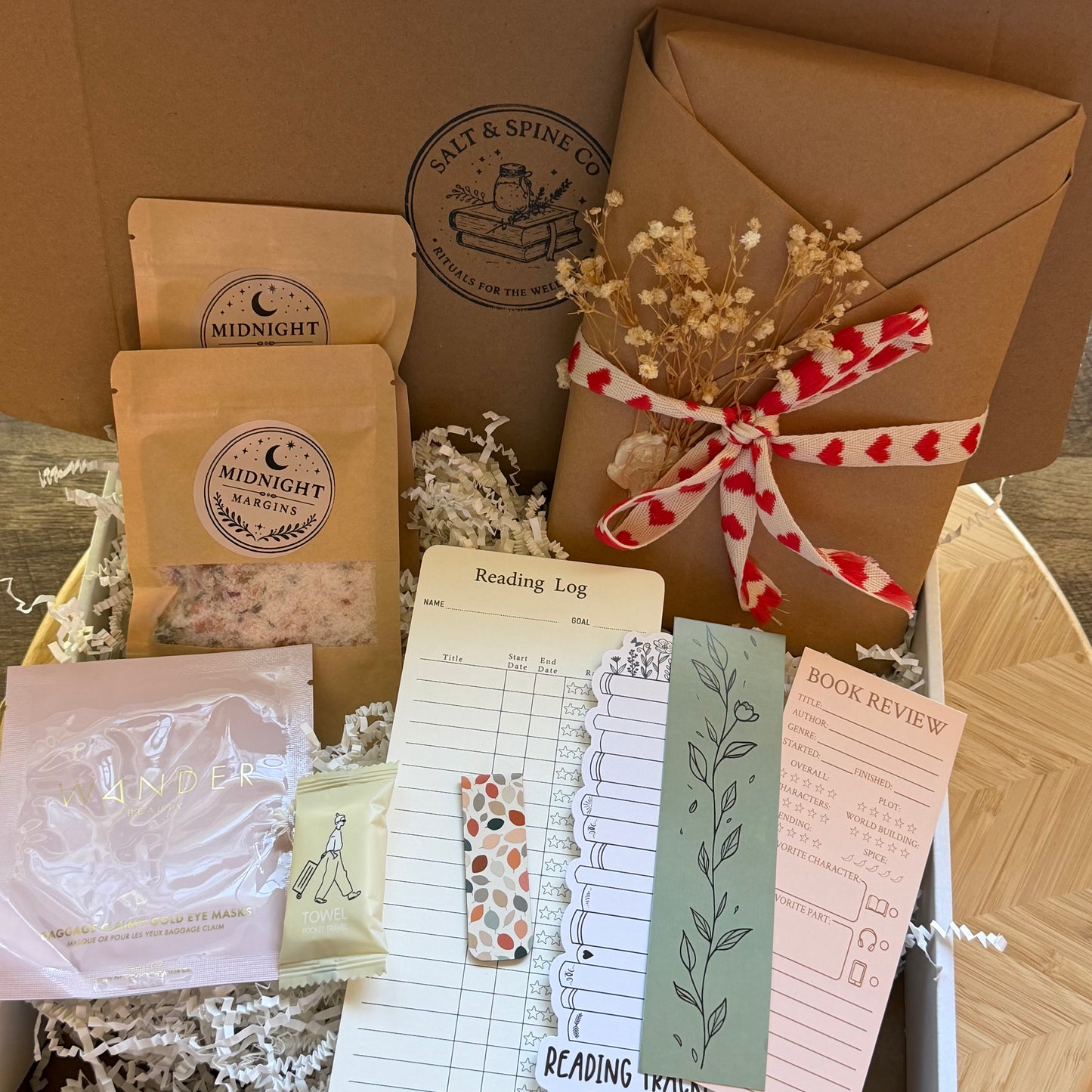 Collection of items including a reading log, bookmarks, and packaged products with 'Salt & Spine Co' branding.